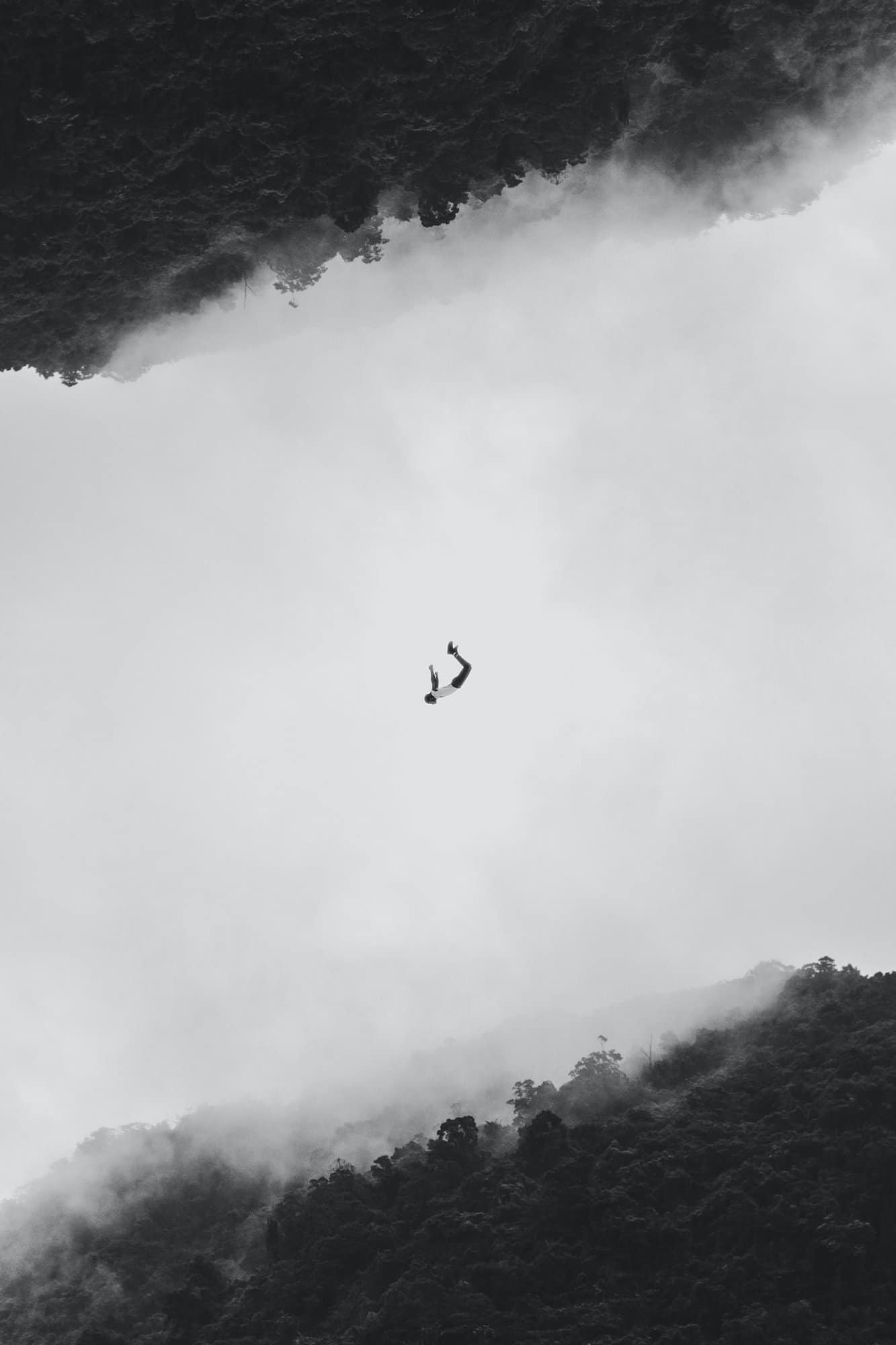 artistic image that shows a falling man in the middle and a dark cloud at the top and bottom